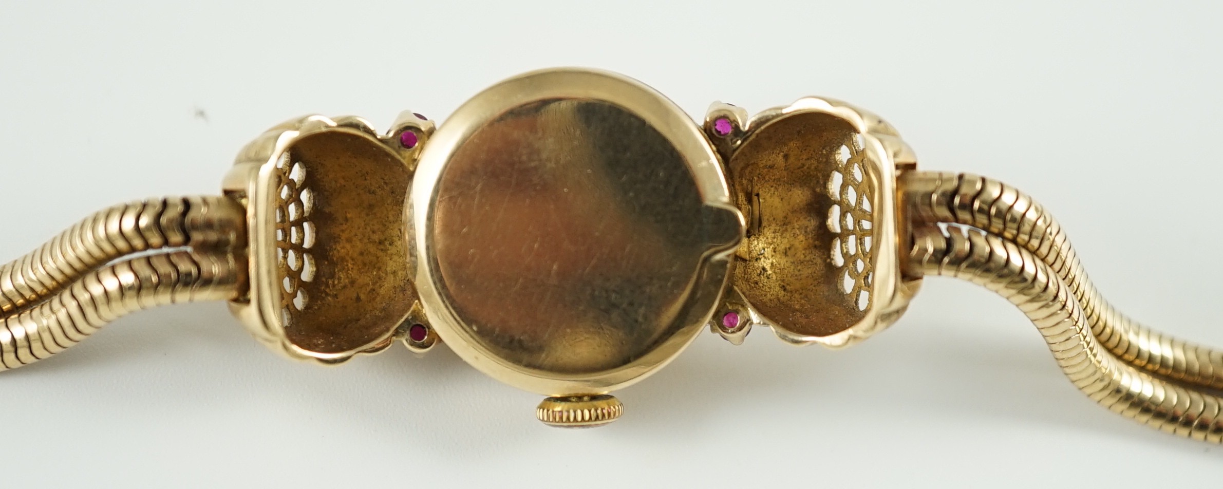 A lady's 1950's 9ct gold, ruby and diamond set manual wind cocktail watch, on a 9ct gold twin strand snake link bracelet